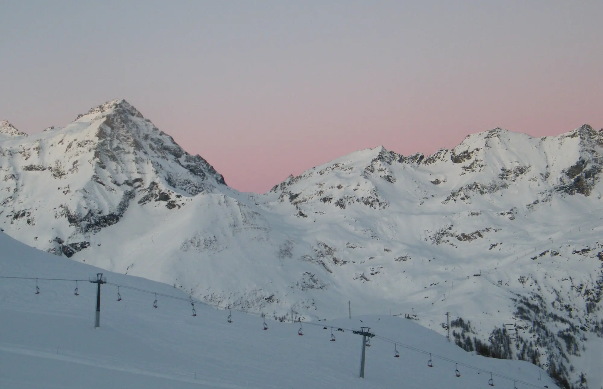 Morning light on the Monte Rosa peaks above ski runs and chairlifts, seen from Rifugio Gabiet in the Monterosa Ski area (Gressoney side)