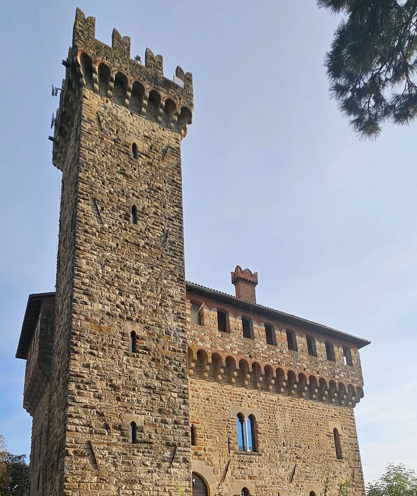 A medieval castle with a crenellated stone tower in evening light, Langhe & Monferrato